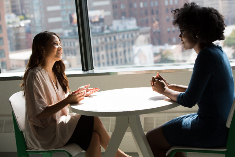 Dos personas conversando sobre la estrategia del negocio en una oficina