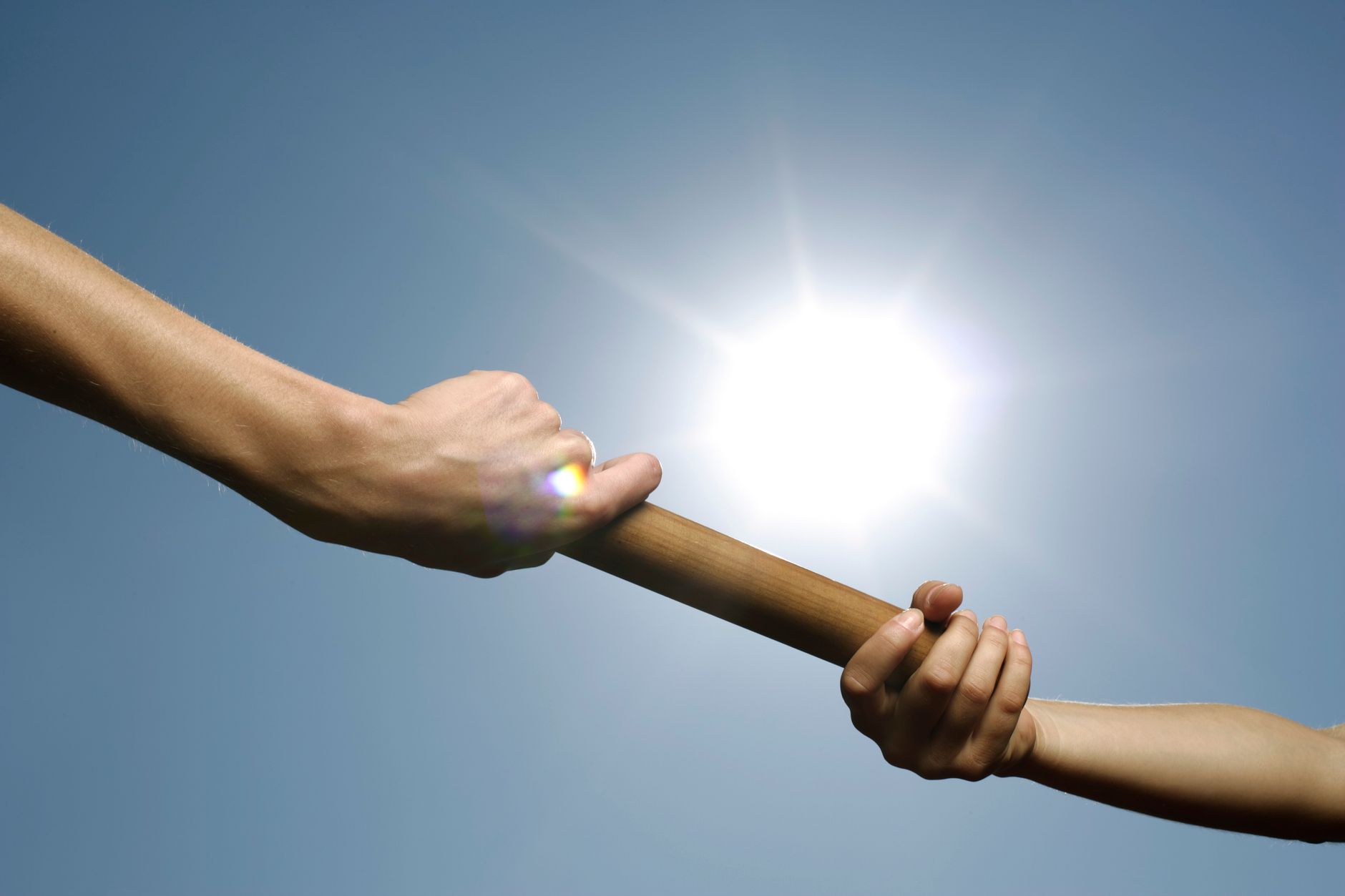 Corredores entregando el testigo en una carrera de relevos